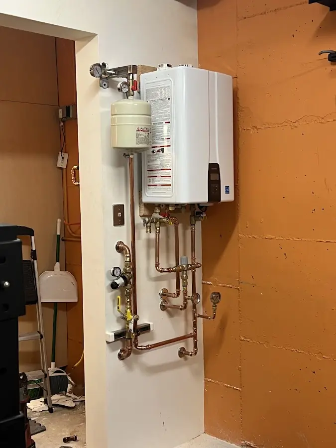 Plumbing technician inspecting water heater connections in Sand Springs